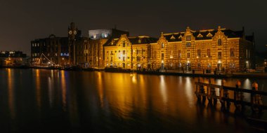 Kurt Hollanda 21 Aralık. 2017. Lassie akşam saatlerinde Zaan nehirde eski fabrika, fabrika hala kullanımda. Zaanse Schans'a olduğunu.