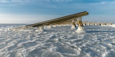 Mavi gökyüzünün altında donmuş deniz deniz inşaatlarda görünümünü
