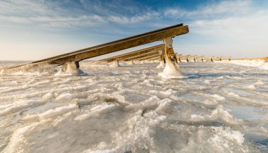 Mavi gökyüzünün altında donmuş deniz deniz inşaatlarda görünümünü