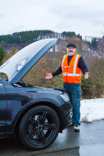 Bir adam bir araba arıza bir ülke yolda vardır.