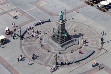 Adam Mickiewicz monument at the Main Market square with walking people.  clipart