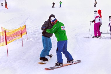 Bir öğrenciyle Tatra Kayak Okulu Strbske Pleso içinde eğitmen snowboard.