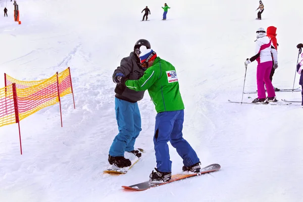 Snowboardlehrer der Skischule Tatra mit einem Schüler in strbske pleso. — Stockfoto