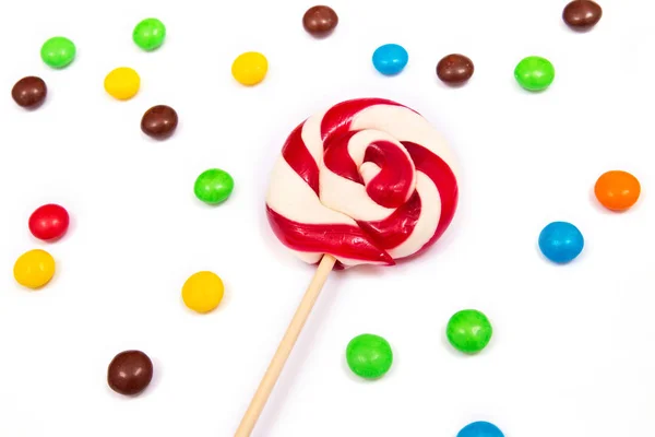 Rood-wit lolly met kleurrijke knop-vormige chocolade — Stockfoto