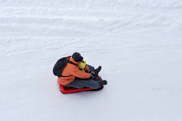 一个孩子的无名男子骑着雪橇. — 图库照片