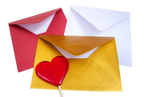 Group of open multicolored envelopes with red lollipop in the shape of a heart. — Stock Photo, Image