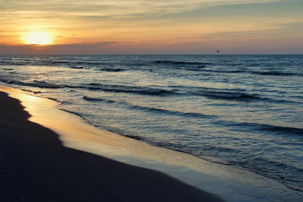 Güneş ve küçük dalgalar ile Baltık Denizi güzel gün batımı.