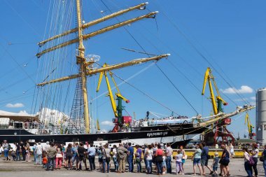 Turistler yakınındaki ünlü barque Kruzenshtern (önceden Padua) Kaliningrad Sea Port iskele içinde demirleyen. 