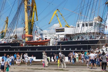 Turistler yakınındaki ünlü barque Kruzenshtern (önceden Padua) Kaliningrad Sea Port iskele içinde demirleyen.
