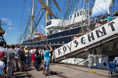 Turistler yakınındaki ünlü barque Kruzenshtern (önceden Padua) Kaliningrad Sea Port iskele içinde demirleyen.