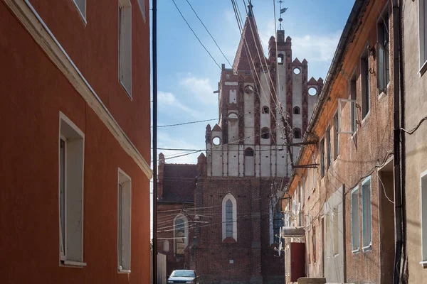 Vista de la Iglesia de San Mártir Jorge el Victorioso en Pravdinsk (Friedland) desde la antigua calle estrecha, Óblast de Kaliningrado, Rusia . —  Fotos de Stock