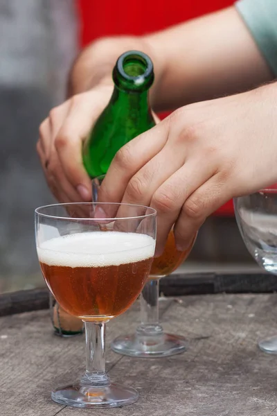 Męskie ręce z butelką piwa belgijskie. — Zdjęcie stockowe