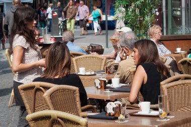 Bilinmeyen insanlar Leuven Merkezi Leopold Vanderkelen Caddesi üzerinde açık bir kafede dinlenme. 