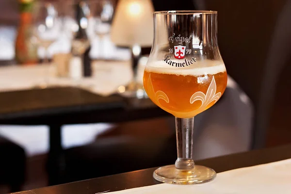 Oryginalne szklane Tripel Karmeliet piwa w jednej z restauracji w mieście Leuven. — Zdjęcie stockowe