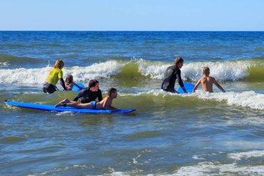 Zelenogradsk, Kaliningrad bölgesi, Rusya Federasyonu - 29 Temmuz 2017: dinlenme ve yaz saati, Baltık Denizi'nin mavi dalgalar üzerinde profesyonel eğitmenler ile sörf öğrenme bilinmeyen çocuk.