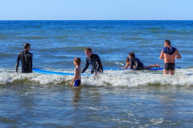 Zelenogradsk, Kaliningrad bölgesi, Rusya Federasyonu - 29 Temmuz 2017: dinlenme ve yaz saati, Baltık Denizi'nin mavi dalgalar üzerinde profesyonel eğitmenler ile sörf öğrenme bilinmeyen çocuk.