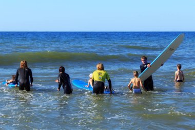 Zelenogradsk, Kaliningrad bölgesi, Rusya Federasyonu - 29 Temmuz 2017: dinlenme ve yaz saati, Baltık Denizi'nin mavi dalgalar üzerinde profesyonel eğitmenler ile sörf öğrenme bilinmeyen çocuk.