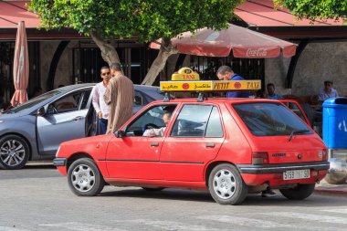 Nador 'un merkezinde küçük kırmızı bir taksi. Bu tür arabalar Fas 'ta şehir sınırları içindeki yolcuları taşımak için kullanılır..