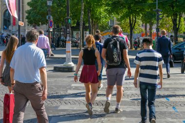 Bilinmeyen gençler Avenue des Champs-Elysees üzerinde Paris'in merkezinde bir yaya geçidi nden geçiyor.