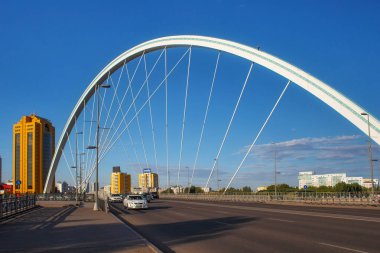 Astana 'nın merkezindeki Ishim Nehri üzerindeki yol ve modern köprüye sahip şehir manzarası.