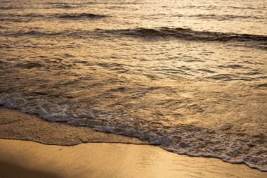 Gün batımında kumlu güzel bir deniz manzarası..