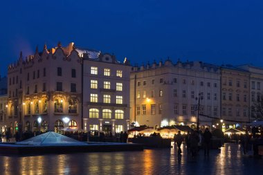 Krakow 'un tarihi merkezindeki Ana Pazar Meydanı' nın gece manzarası Noel fuarlarına yakın..