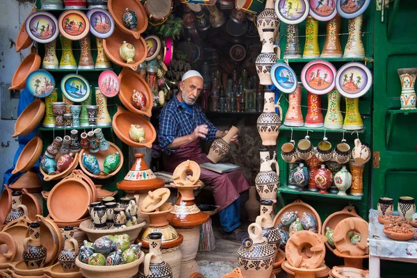 Un inconnu travaille avec des pots souvenirs dans son atelier de rue dans le quartier de Tétouan Medina dans le nord du Maroc . — Photo