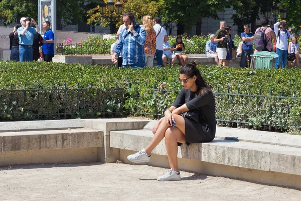 Unknown young woman resting on the place Jean Paul II (Parvis Notre-Dame) in center of Paris. — Stock Photo, Image