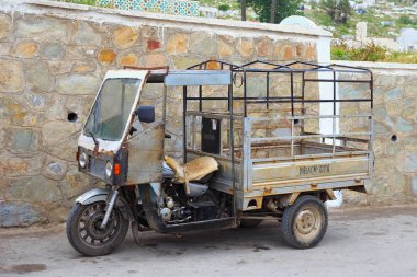 Kuzey Fas 'taki Tetouan caddelerinde eski paslı üç tekerlekli bisiklet.. 