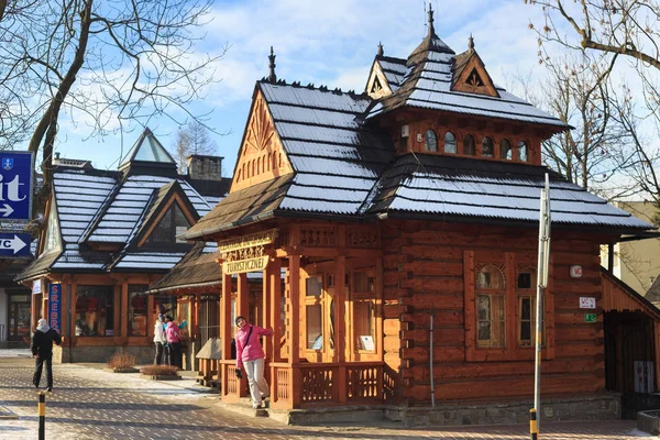 Pohled na dřevěnou budovu Turistického informačního centra v historické části Zakopane na ulici Tadeusza Kosciuszki ve slunném zimním dni. — Stock fotografie