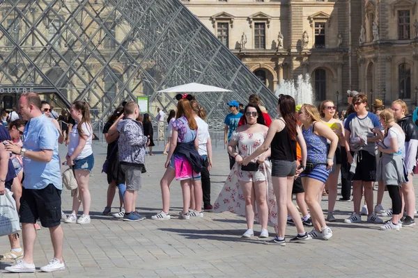 Ismeretlen a fiatal turisták közelében a híres Üvegpiramis a Múzeum Louvre. — Stock Fotó