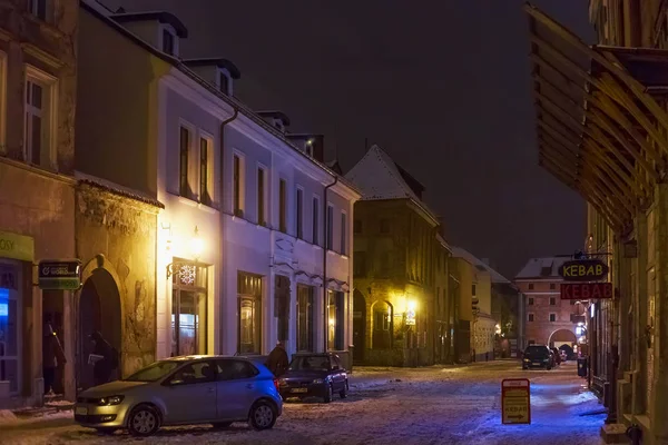 Nattlig vinter utsikt över de gamla byggnaderna i den historiska delen av Torun på Ducha Swietego gatan. — Stockfoto