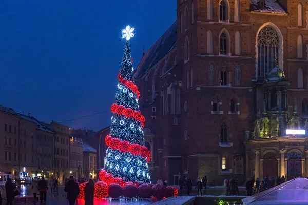 Wieczorny widok zimowy choinki w pobliżu słynnej gotyckiej Bazyliki Mariackiej na Rynku Głównym w historycznym centrum Krakowa. — Zdjęcie stockowe