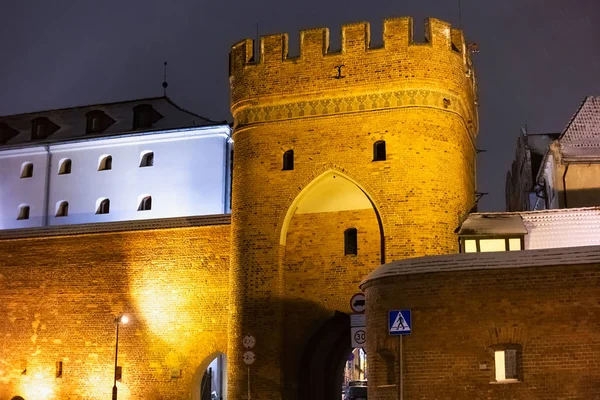 Ночной зимний вид на мостовые ворота в исторической части Торуни, Польша . — стоковое фото