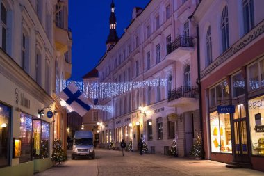 Tallinn 'in tarihi kısmında Noel süslemeleri olan eski sokakların gece manzarası.