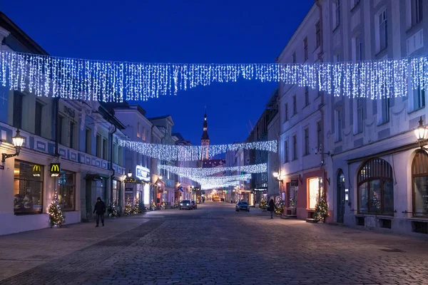 Nocny malowniczy widok zimowy na stare ulice z ozdobą świąteczną w historycznej części Tallina z niebieskim wieczornym niebem na tle. — Zdjęcie stockowe