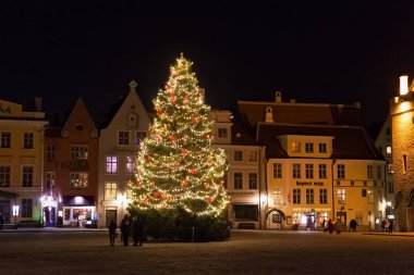 Tallinn, Estonya - 12 Ocak 2018: Tallinn 'in tarihi bölümünde yer alan ünlü Raekoja plakalarındaki Noel ağacının gece manzarası.