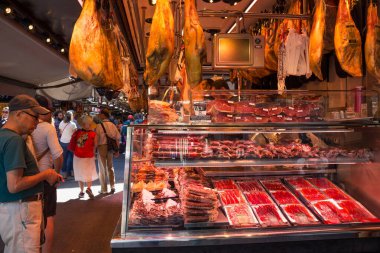 BARCELONA, İspanya - 16 Mayıs 2017: Barcelona 'daki ünlü La Boqueria pazarında jamon ve diğer et lezzetleri indirimi.