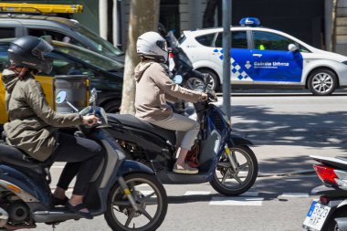 BARCELONA, SPAIN - 16 Mayıs 2017: Güneşli bir günde Barcelona 'nın merkezinde bilinmeyen kadınlar scooterlara biniyor.