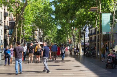Barselona, İspanya - 16 Mayıs 2017: Bilinmeyen turistler Barselona 'nın tarihi merkezinde La Rambla' da yürüyor.