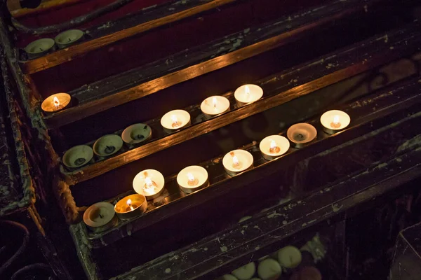 Burning candles from paraffin wax in a church on a stand
