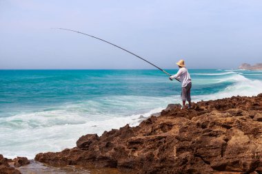 TANGIER, MoroCCO - 27 Mayıs 2017: Güneşli bir günde Atlantik Okyanusu kıyısında bilinmeyen balıkçı.