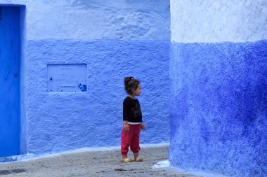 CHEFCHAOUEN, FOCCO - 28 Mayıs 2017: Medine, Chaouen 'de bilinmeyen genç kız. Şehir binalarının mavi tonlarıyla ünlüdür ve bu Şef 'i ziyaretçiler için çok çekici kılar..