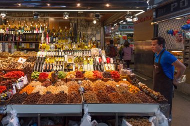 BARCELONA, İspanya - 16 Mayıs 2017: Barcelona 'daki ünlü La Boqueria pazarında farklı tatlı, fındık, kuru meyve ve sebze, yağ ve diğer ürünlerin satışı.