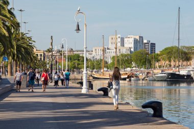 BARCELONA, İspanya - 16 Mayıs 2017: Barcelona 'nın merkezindeki Port Vell' de Moll de Bosch i Alsina caddesinde yürüyen meçhul insanlar.