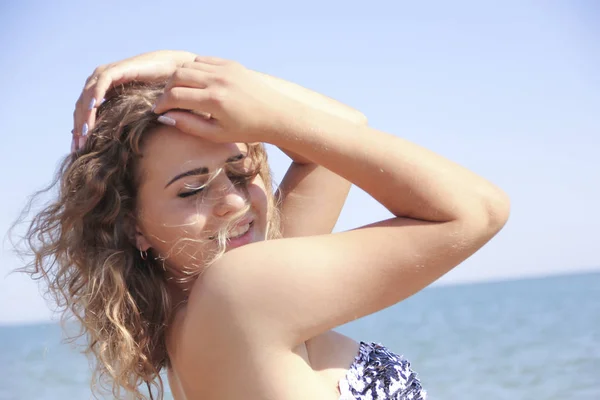 Hermosa chica sonríe contra el mar — Foto de Stock