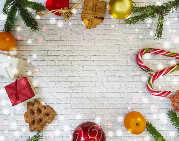 Weihnachtskomposition. Weihnachtsgeschenk, Tannenzapfen, Lebkuchen, Tannenzweige mit Bonbons, Lutscher auf ziegelweißem Hintergrund. flach, von oben gesehen. Mandarinen, Kekse, Bokeh — Stockfoto