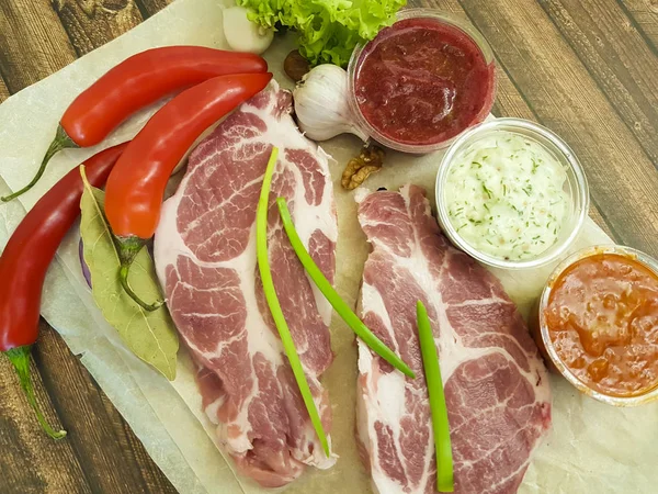 Carne crua em um conselho de pimentão de madeira, manteiga, molho, nozes, pimentão, limão, pimentão baia, alho, comida orgânica, receita — Fotografia de Stock