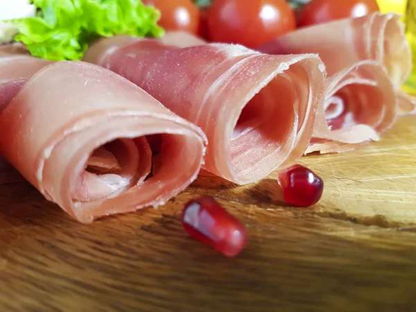 Jamon wooden board cherry tomato, oil, pomegranate, corn — Stock Photo, Image