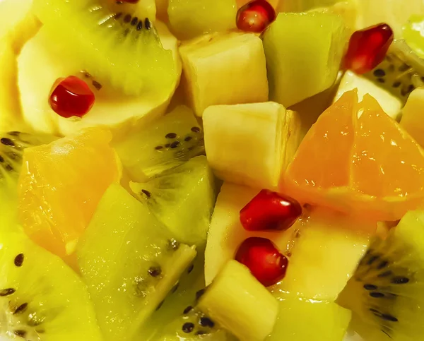 , ,       , , ,   fruktovyy salat banan, kivi,Apel'sin , granat fon  fruit salad banana, kiwi, orange, pomegranate background — Stock Photo, Image